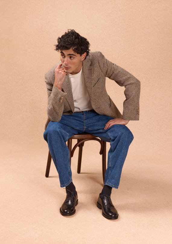 Homme assis sur une chaise portant des mocassins noir