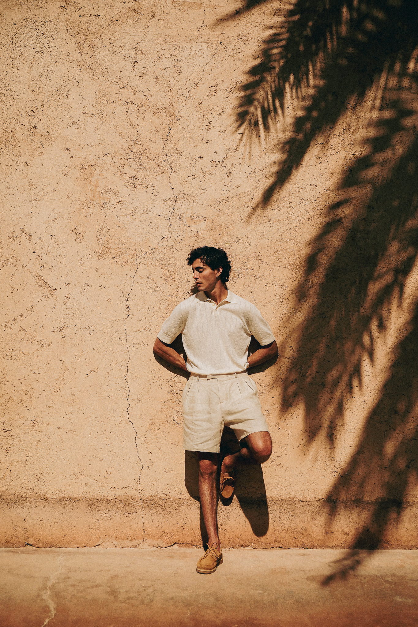 homme debout contre un mur portant des mocassins beige